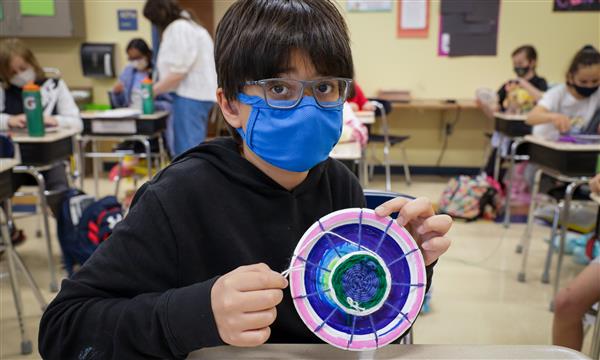 student creates woven craft